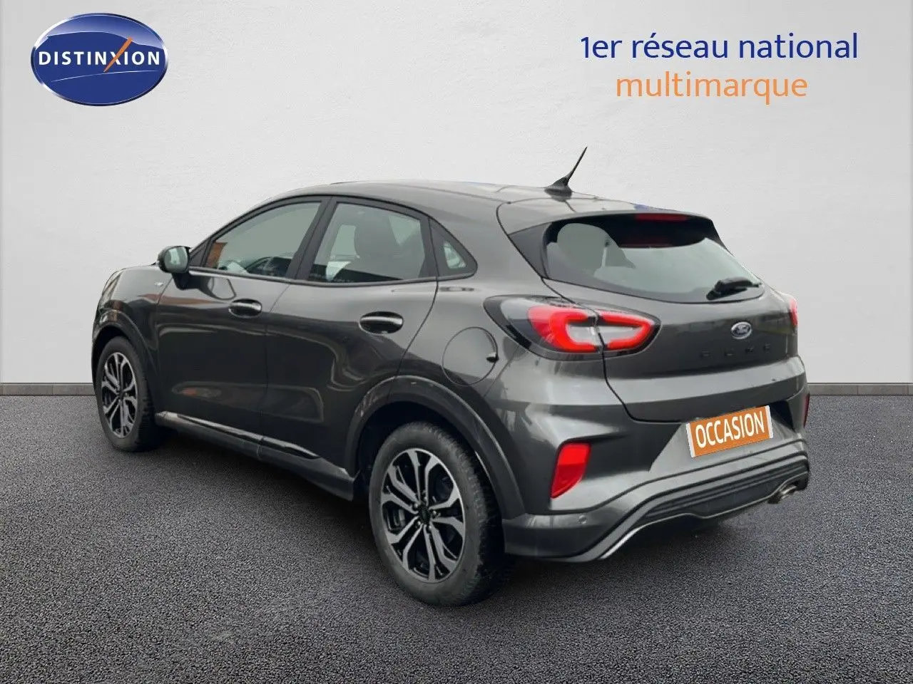 Ford Puma gris magnétique vue 3/4 arrière côté gauche, avec feux arrière LED et jantes alliage noires.