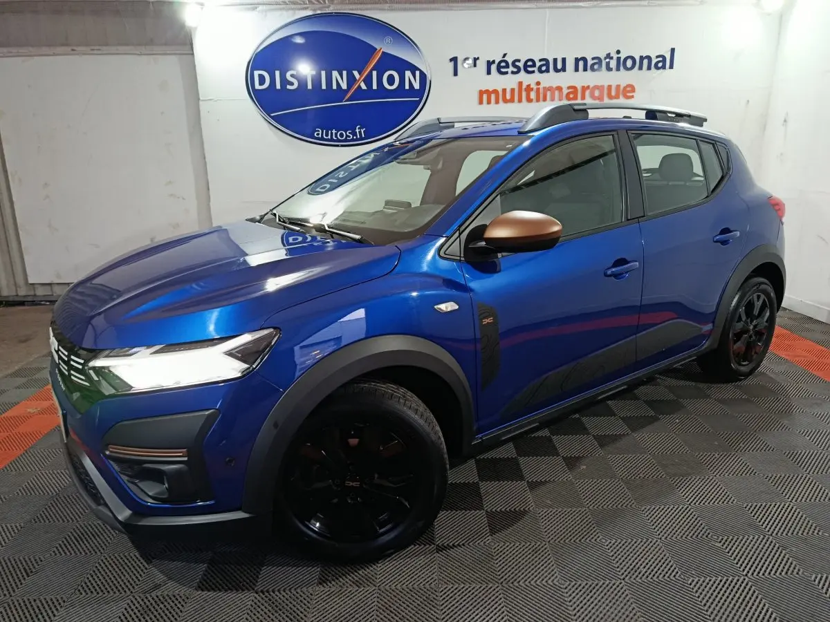 Vue 3/4 avant droite d'une Dacia Sandero Extreme+ TCe 110 bleu avec rétroviseurs bronze et jantes noires.