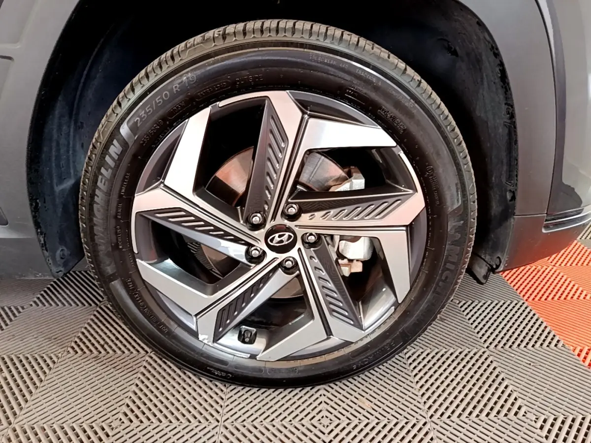 Gros plan sur la jante alliage 19 pouces du Hyundai Tucson gris foncé, avec pneu Michelin visible.
