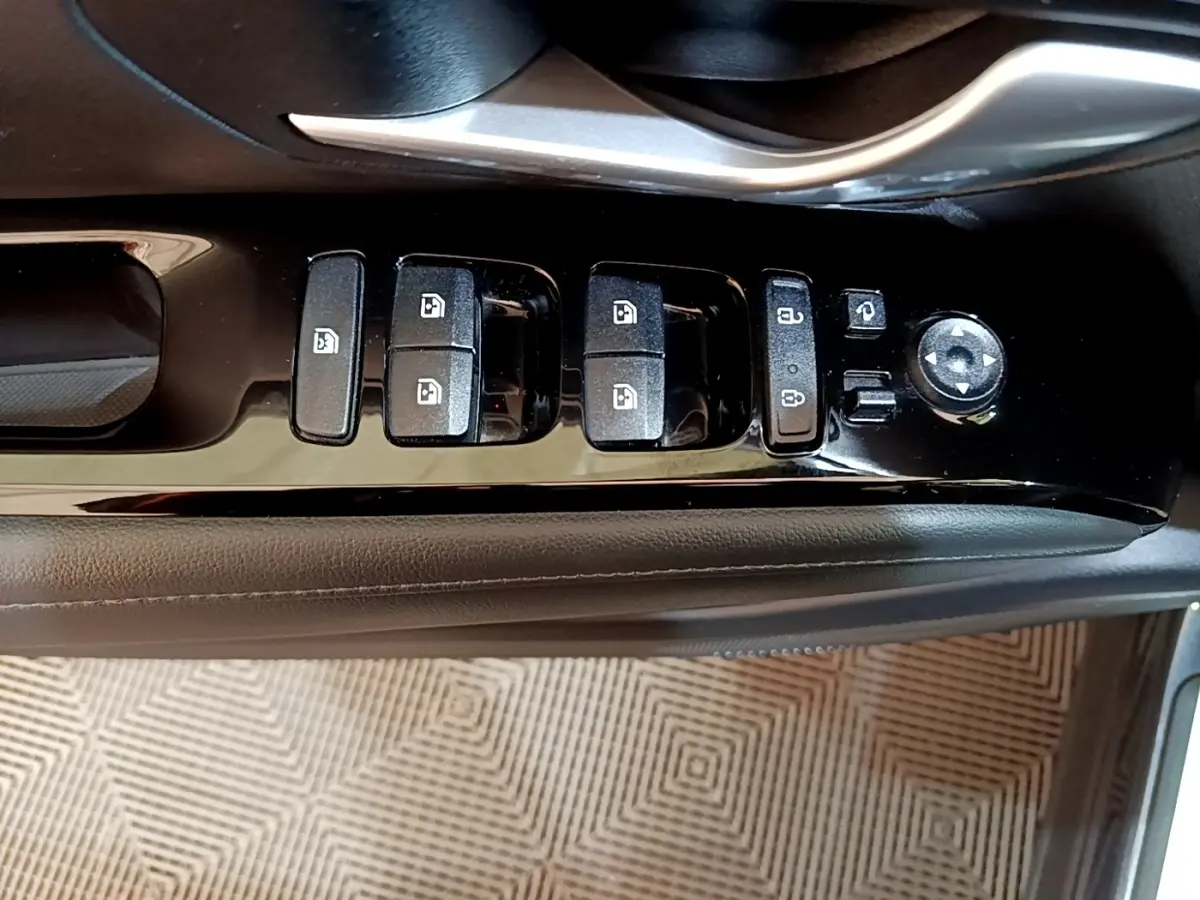 Gros plan sur les commandes de lève-vitres et rétroviseurs côté conducteur du Hyundai Tucson gris foncé, intérieur noir.