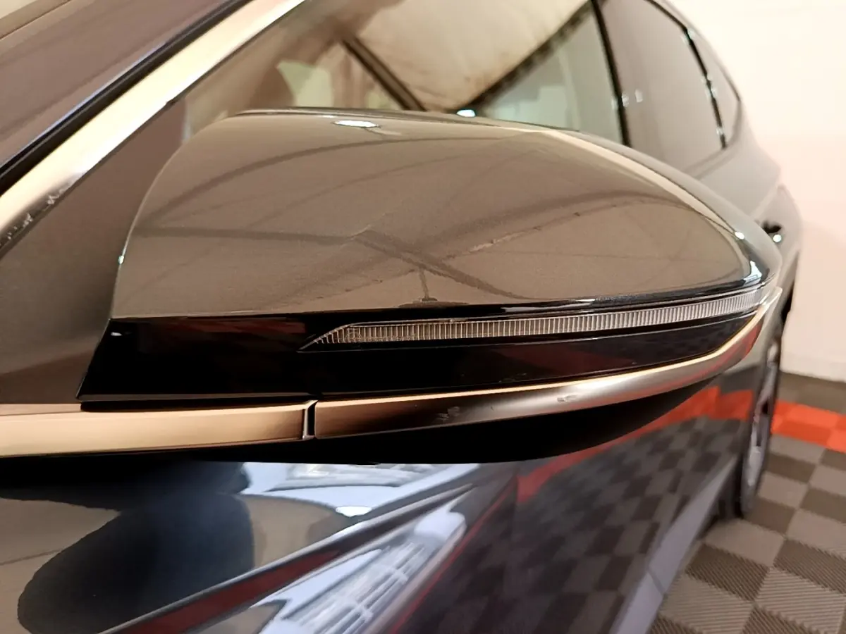 Rétroviseur droit gris foncé du Hyundai Tucson 2022, avec clignotant intégré et carrosserie visible en arrière-plan.