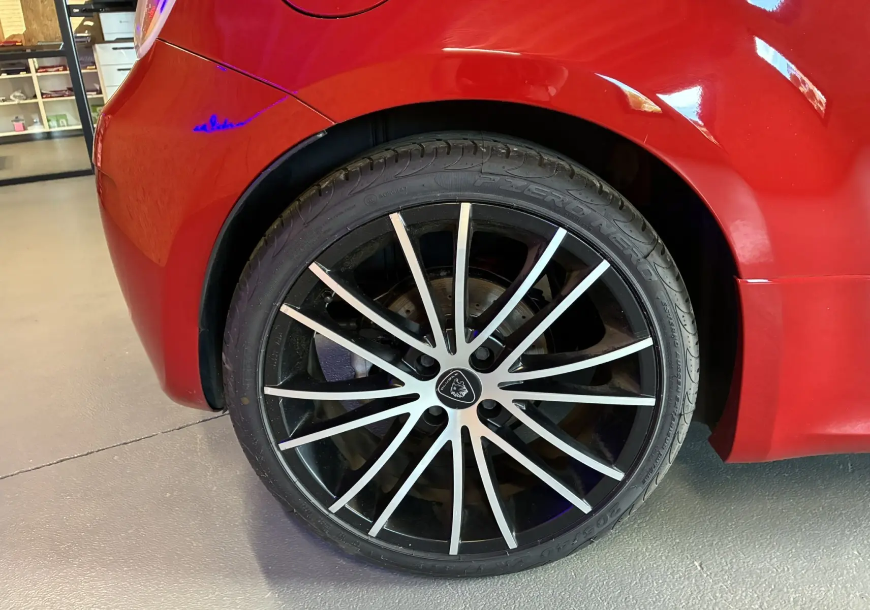 Gros plan sur la roue arrière droite de l'Abarth 500 Competizione 2016 rouge et gris avec jante noire à branches fines.