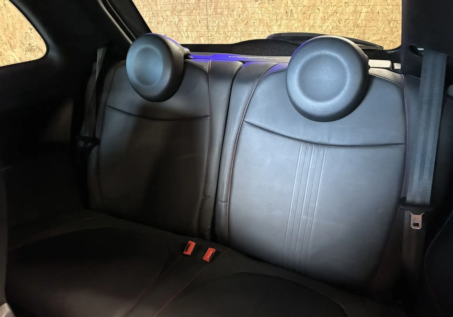 Vue intérieure des sièges arrière en cuir noir de l'Abarth 500 Competizione 2016, avec appuie-têtes ronds.