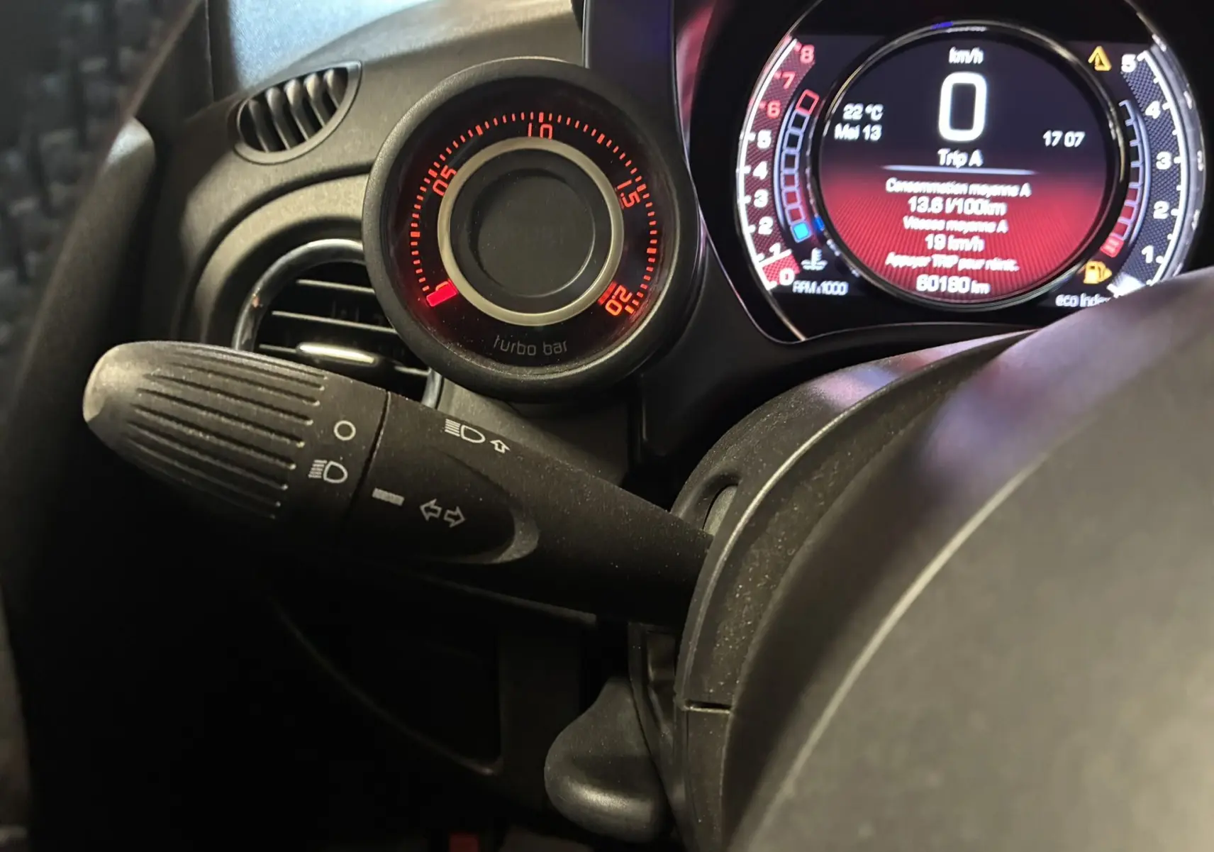 Gros plan sur le tableau de bord de l'Abarth 500 Competizione 2016, affichage numérique rouge et gris avec manomètre turbo.