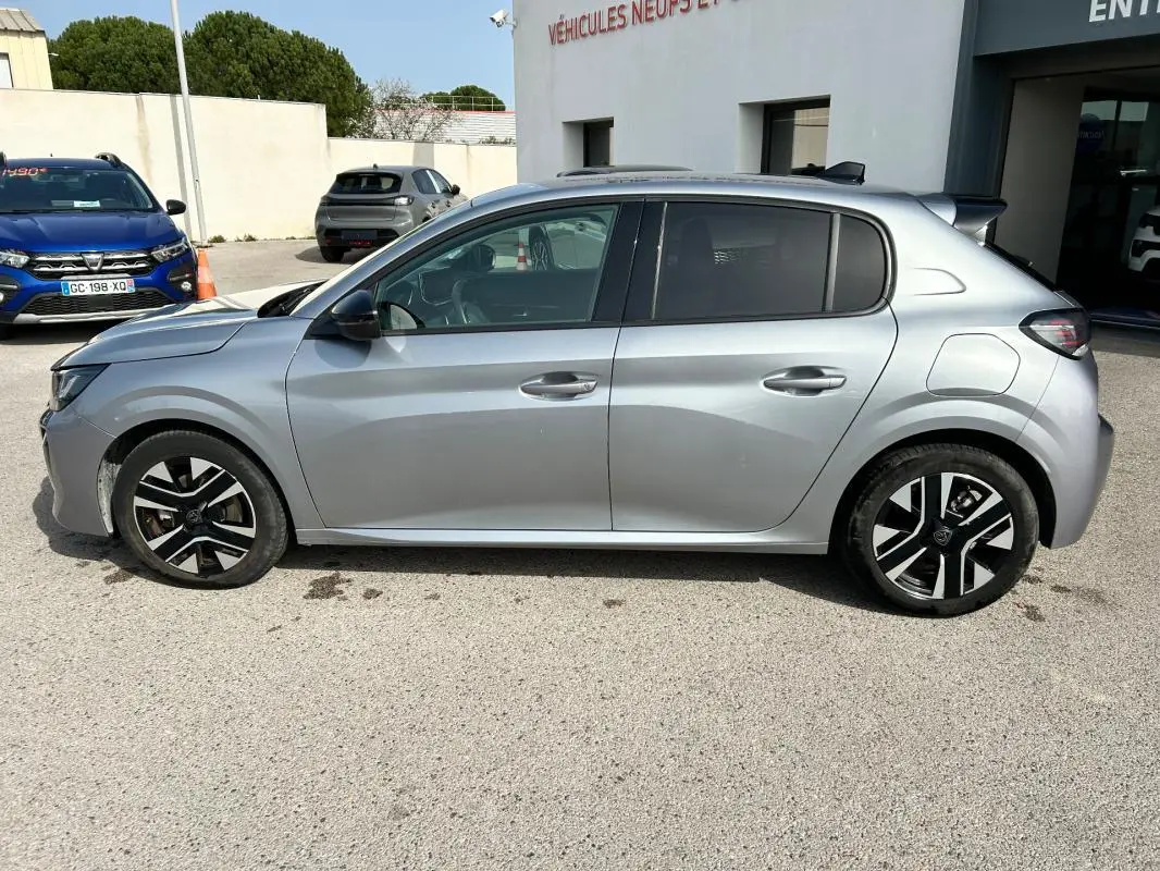 Profil côté gauche d'une Peugeot 208 gris métallisé 2024, avec jantes noires et détails modernes sur les portes.