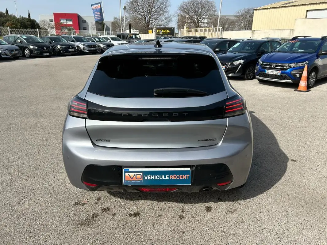 Vue arrière d'une Peugeot 208 Hybrid 110 gris 2024, avec feux LED distinctifs et vitrage arrière teinté.