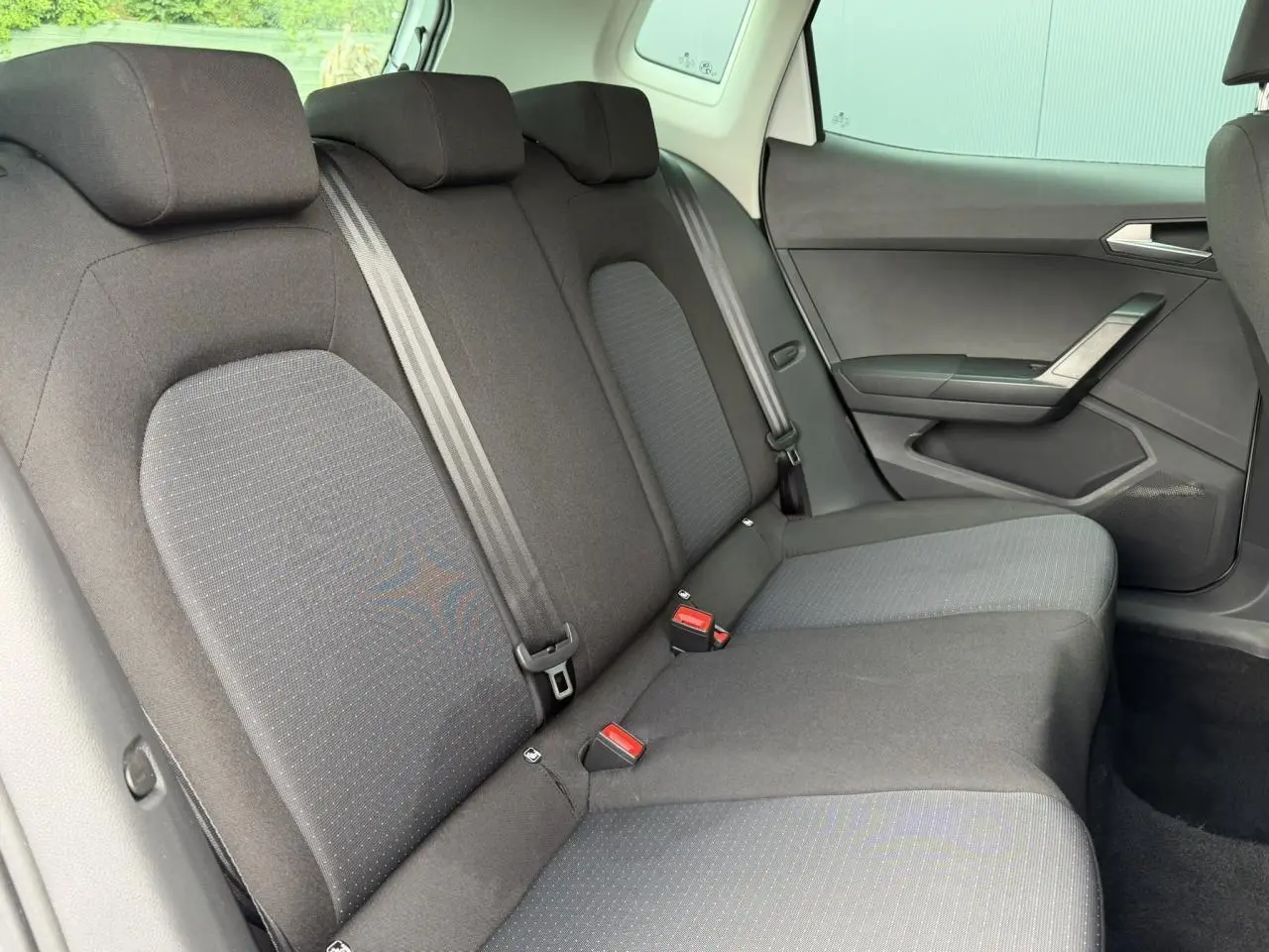 Vue intérieure côté droit des sièges arrière noirs du SEAT Arona TSI 115 Style 2025 avec ceintures et fixations ISOFIX visibles.