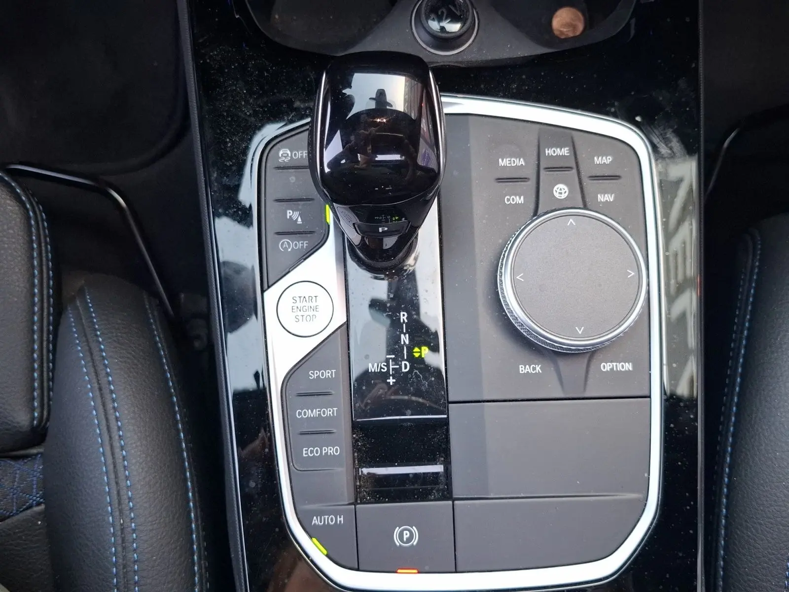 Vue plongeante sur la console centrale noire brillante de la BMW Série 1 118D M Sport avec levier de vitesse et commandes.