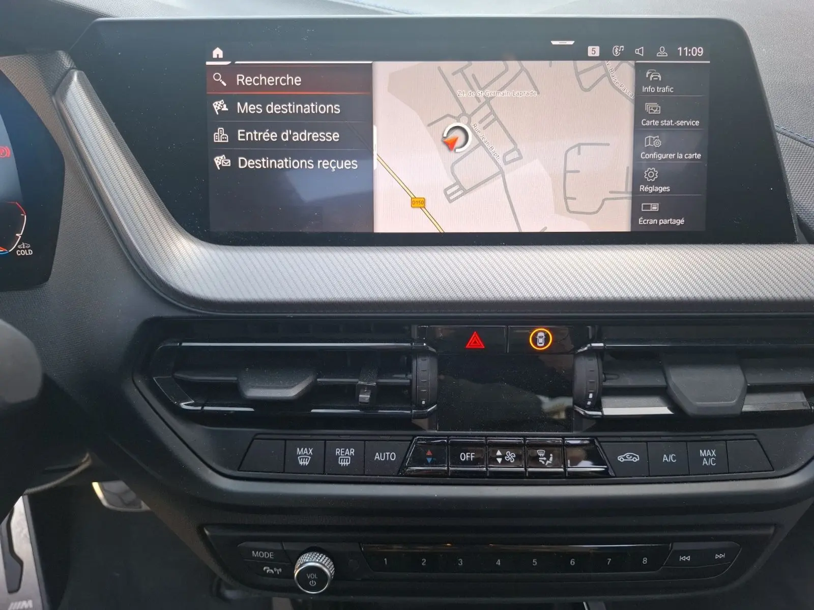 Vue rapprochée de la console centrale de la BMW Série 1 118D M Sport blanche, affichant l'écran GPS et commandes climatisation.