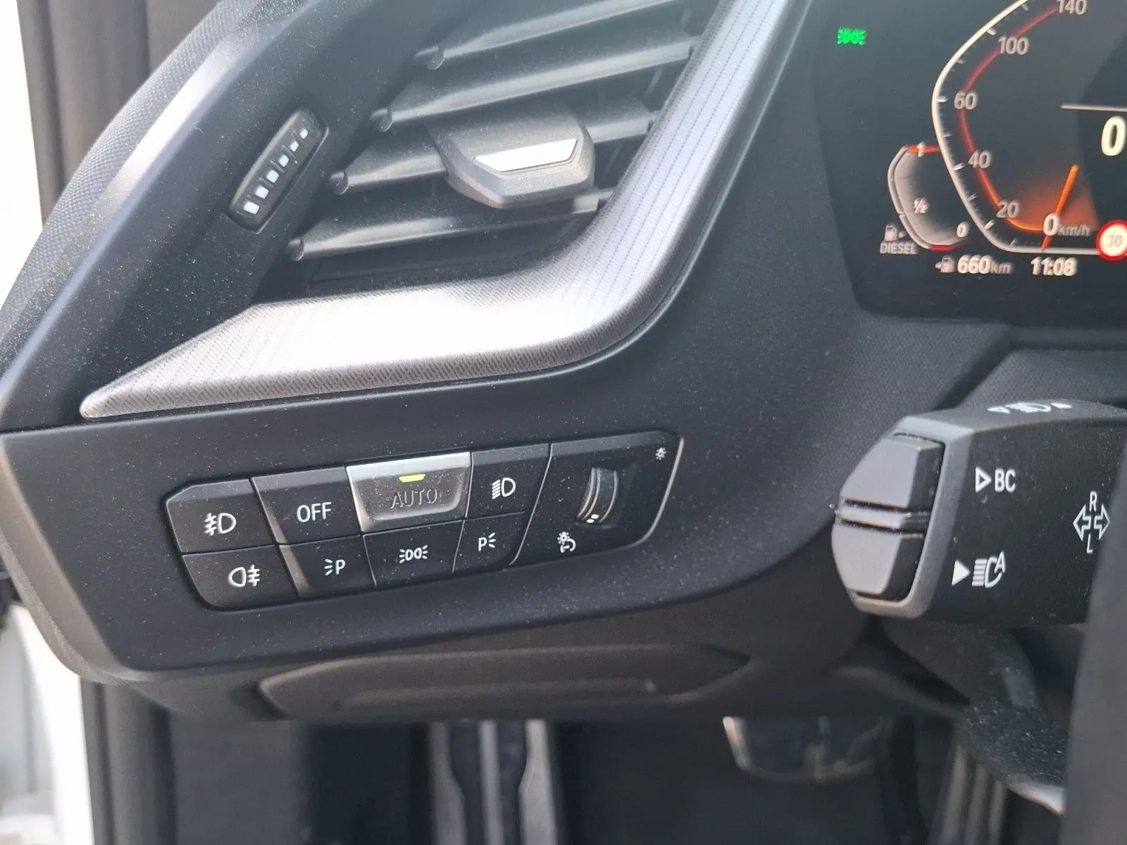 Gros plan sur les commandes d’éclairage et la commande au volant côté gauche d’une BMW Série 1 118D M Sport.