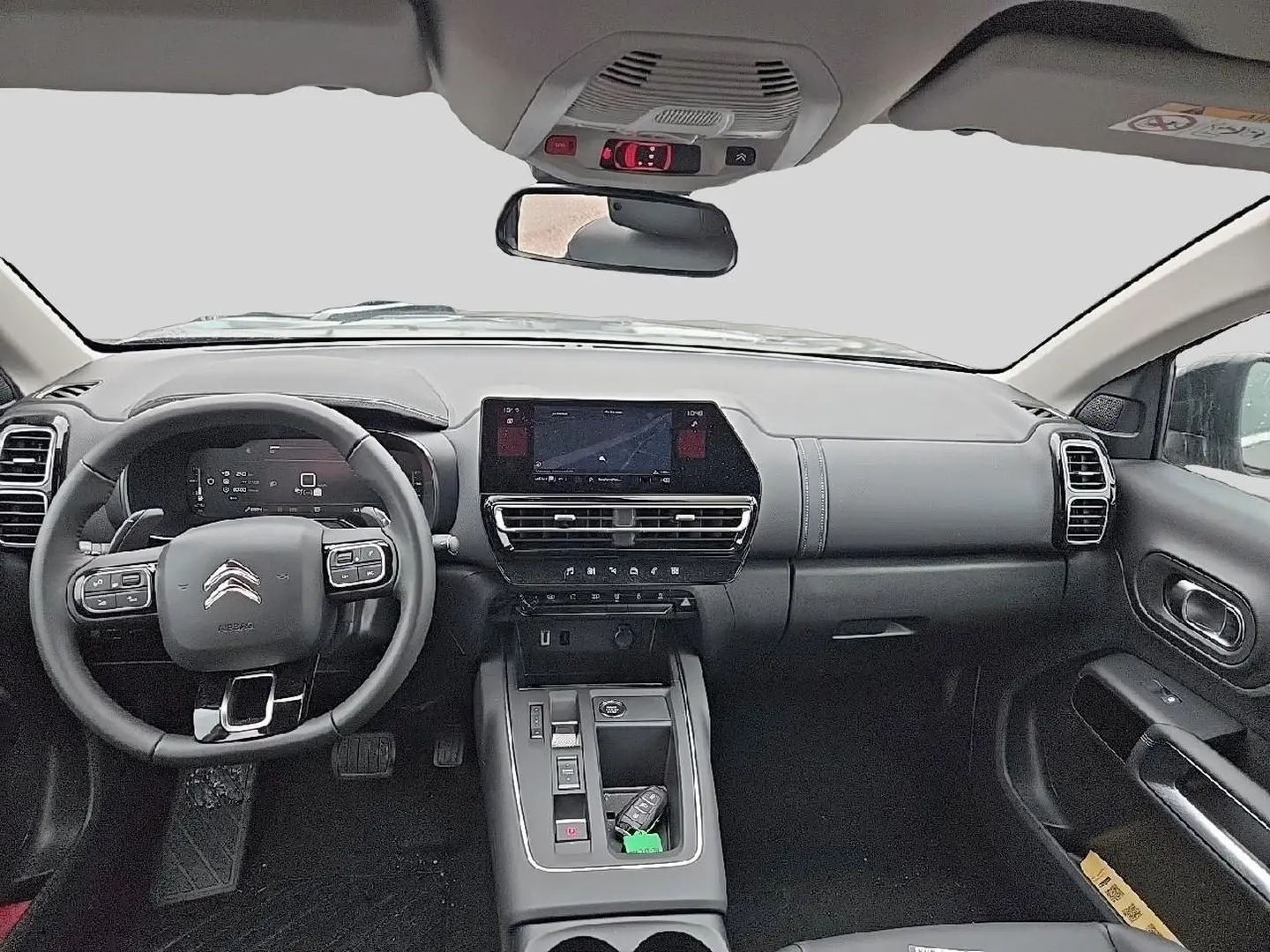 Vue intérieure avant du Citroën C5 Aircross gris 2025, tableau de bord moderne avec écran tactile et volant multifonction cuir.