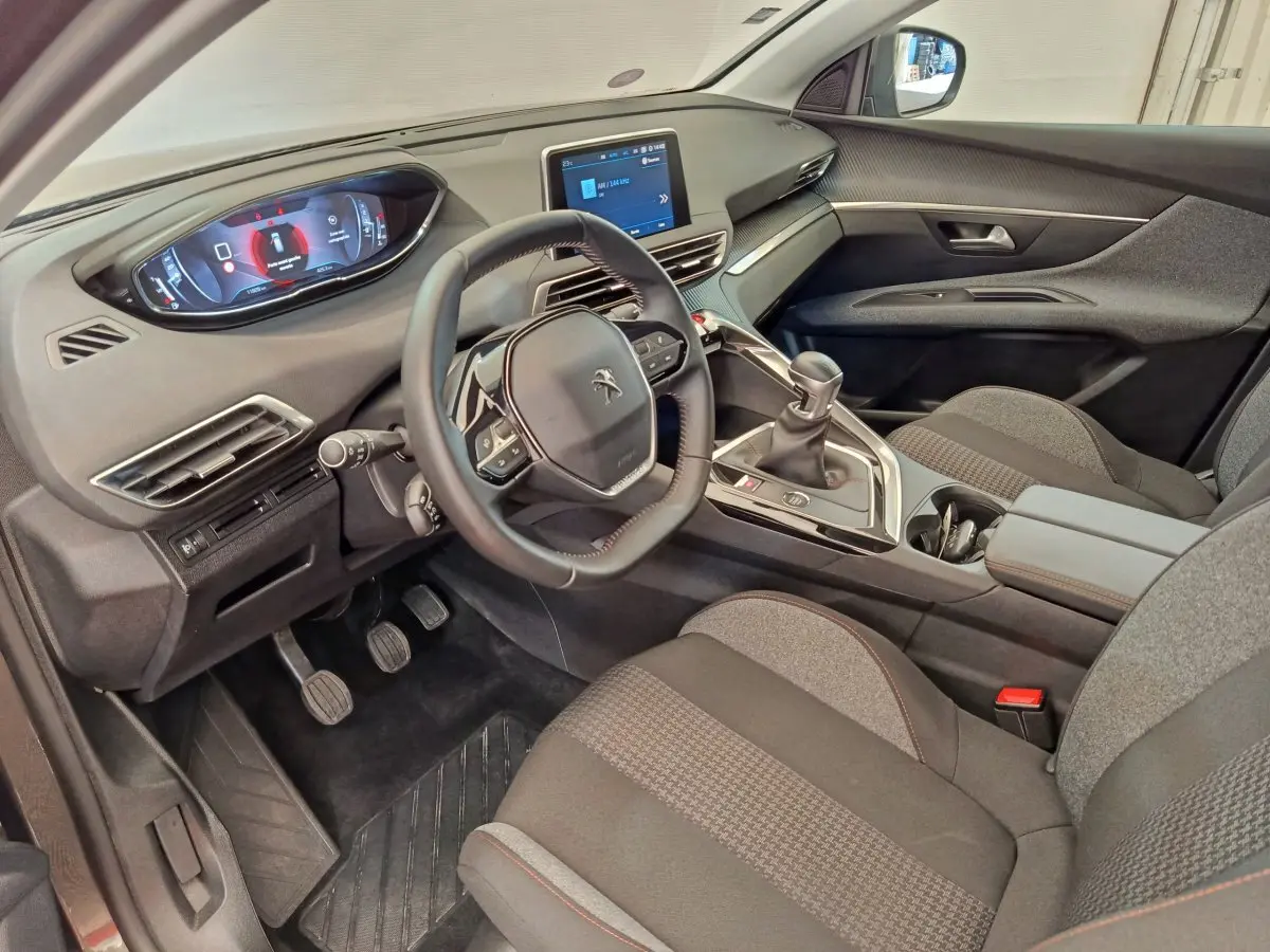 Intérieur côté conducteur du Peugeot 3008 gris foncé, avec tableau de bord numérique et écran tactile central.
