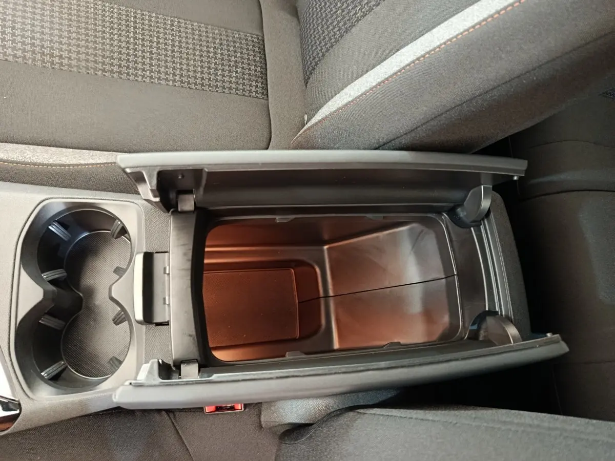 Vue plongeante sur le rangement central ouvert et les porte-gobelets du Peugeot 3008 gris foncé, intérieur tissu.