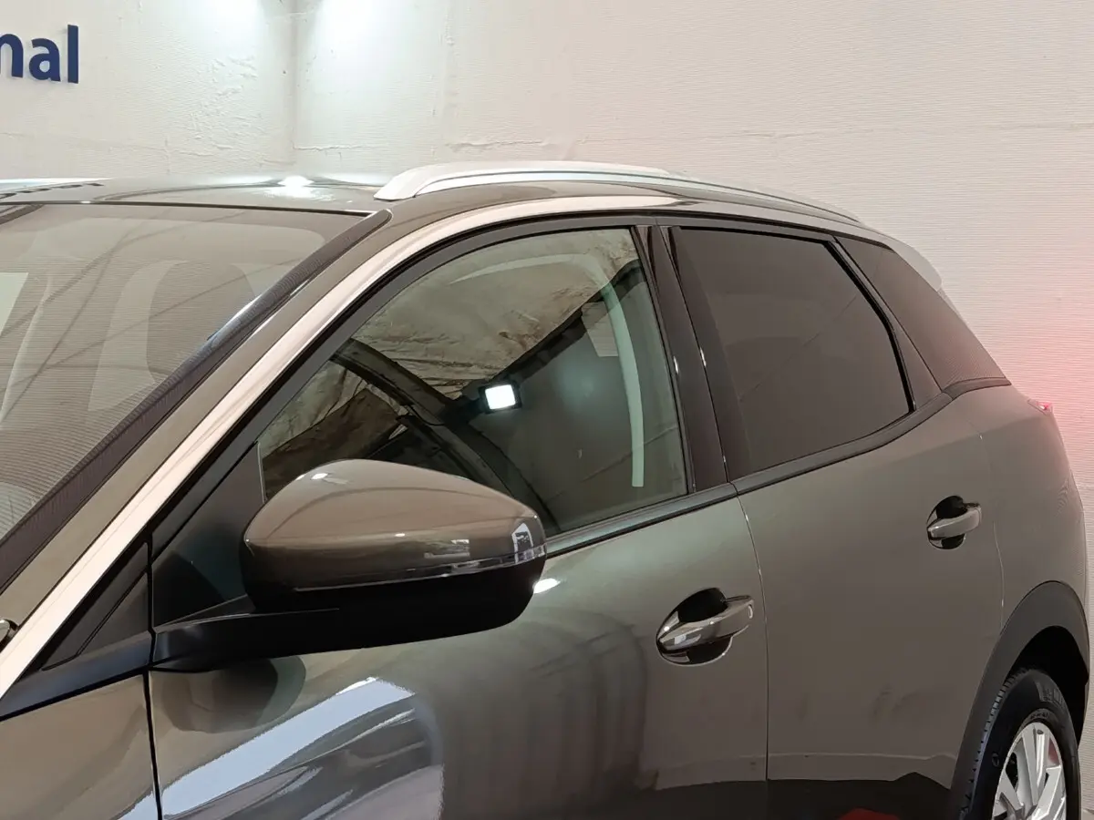 Profil côté gauche du Peugeot 3008 gris foncé 2020, mettant en valeur les vitres teintées et les rétroviseurs intégrant les clignotants.