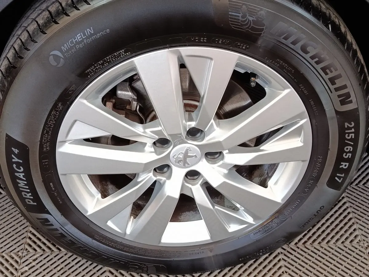 Gros plan sur la jante argentée et le pneu Michelin du Peugeot 3008 gris foncé, version Puretech 130 S&S Active Business.