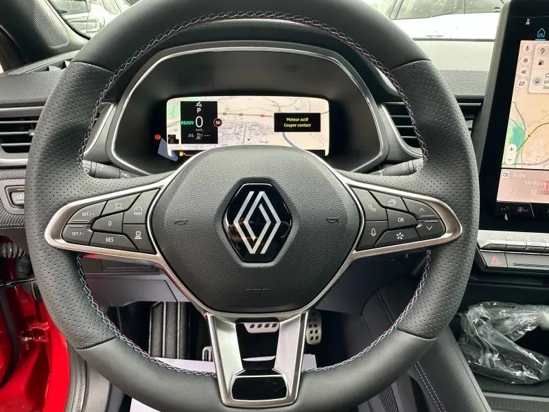 Vue rapprochée du volant perforé du Renault Captur 2025 esprit Alpine avec commandes intégrées et tableau de bord numérique.