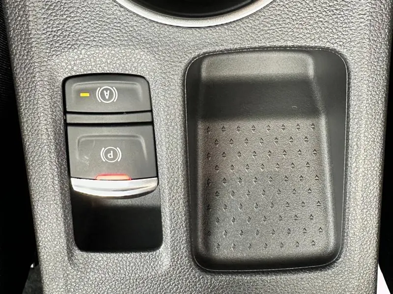 Gros plan sur les commandes de frein à main électronique et arrêt auto du Renault Captur 2025, finition Rouge Flamme/Noir Etoilé.