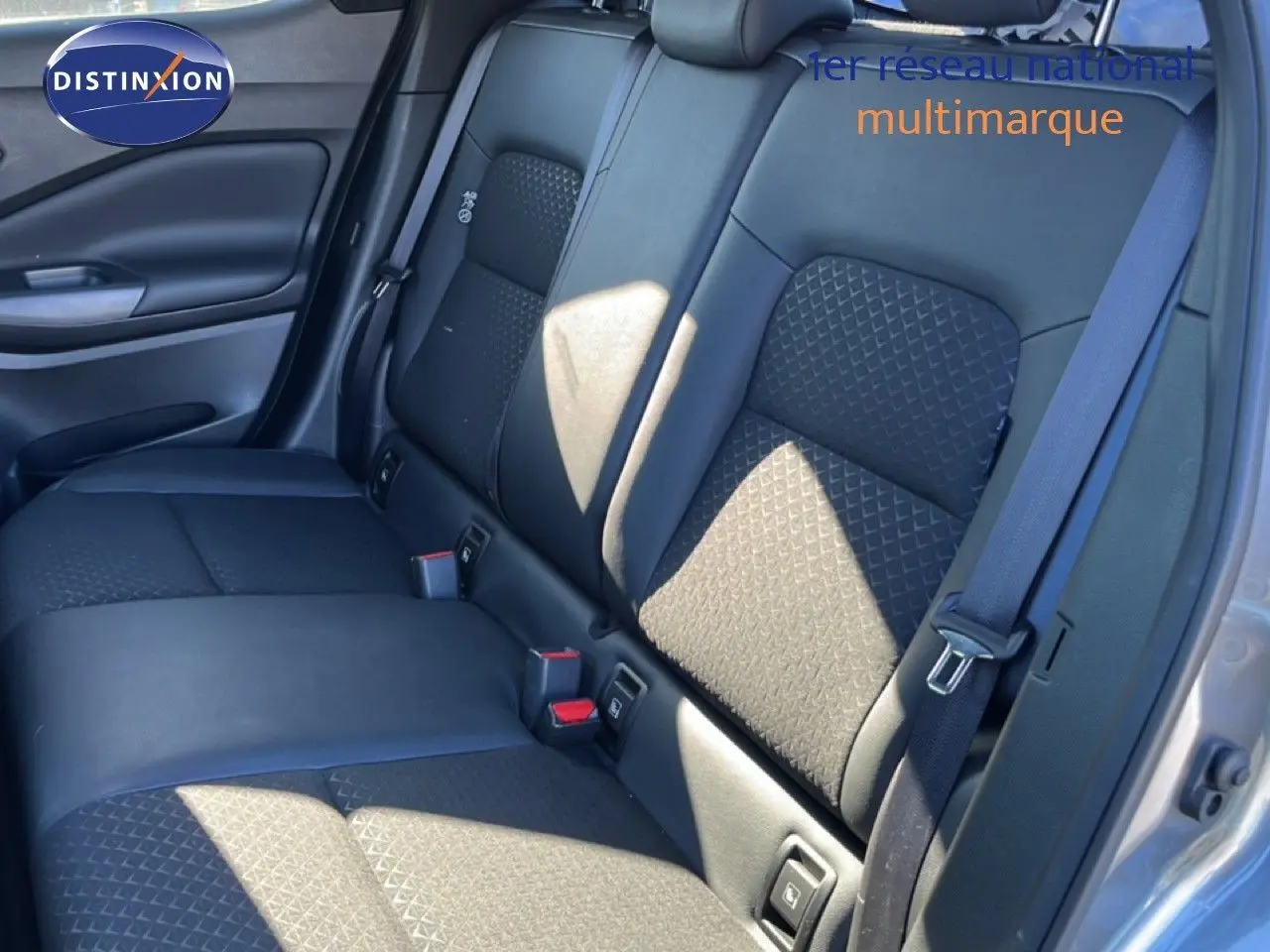 Vue intérieure de la banquette arrière en cuir noir du Nissan Juke Hybrid 2024, côté droit avec ceinture de sécurité visible.