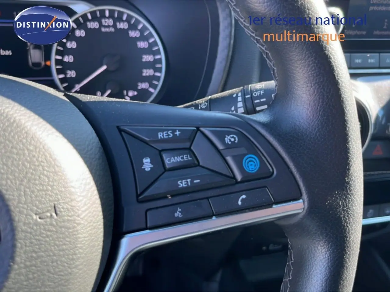 Gros plan sur les commandes au volant à droite du tableau de bord du Nissan Juke Hybrid gris squale métal 2024.