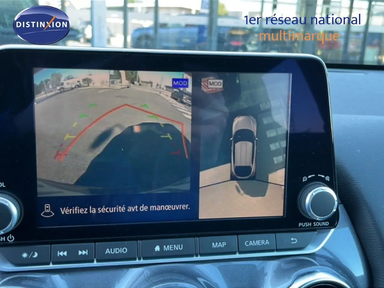 Écran intérieur de la Nissan Juke Hybrid 2024 montrant la caméra de recul et la vue à 360° en stationnement.