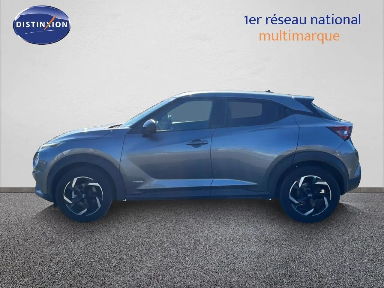 Profil droit du Nissan Juke Hybrid gris squale metal 2024 avec jantes noires et détails modernes.