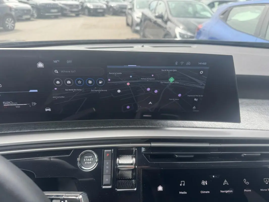 Vue intérieure du tableau de bord du Peugeot 5008 Hybrid 2025 avec écran tactile de navigation et bouton start/stop.