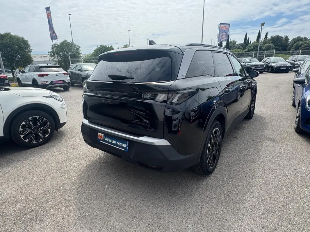 Peugeot 5008 Hybrid noir vu 3/4 arrière droit, avec barres de toit et jantes alliage 19 pouces visibles.