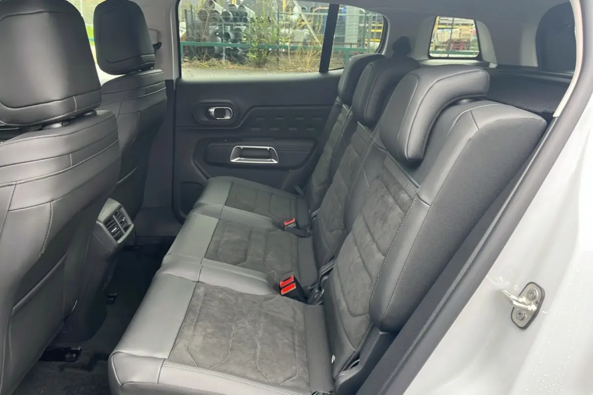 Vue latérale droite des trois sièges arrière individuels en cuir noir du Citroën C5 Aircross blanc okénite, intérieur spacieux.