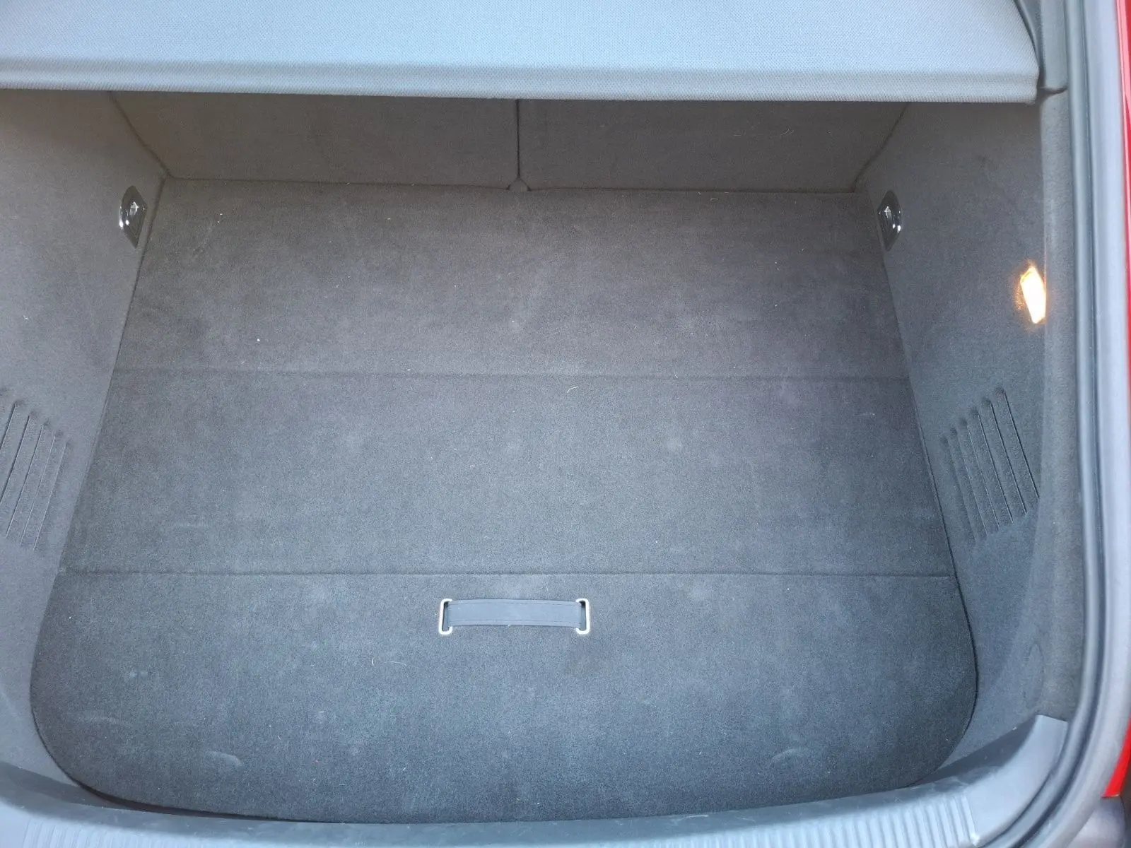 Coffre ouvert vu de dessus d’une Audi TT rouge 3.2 V6 Quattro de 2007, avec intérieur de coffre en tissu noir.