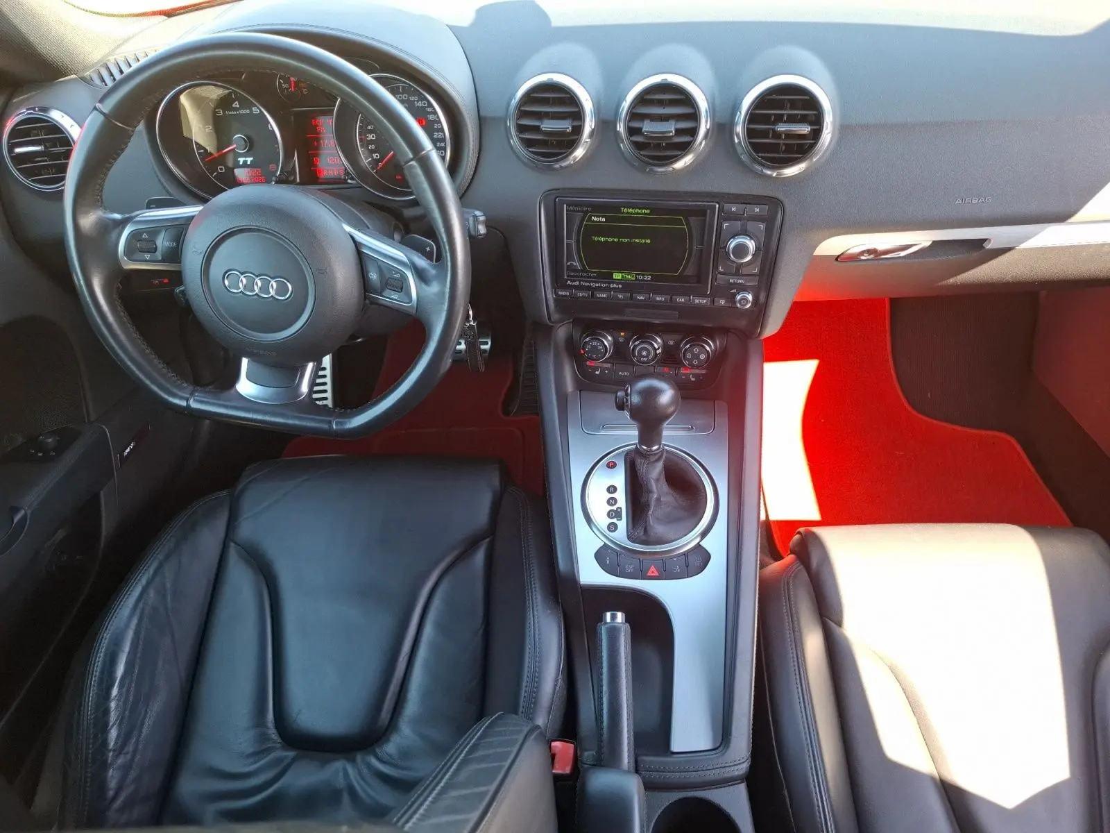 Vue intérieure de l'Audi TT 3.2 V6 Quattro 2007, sellerie cuir noire, volant avec palettes et console centrale argentée.