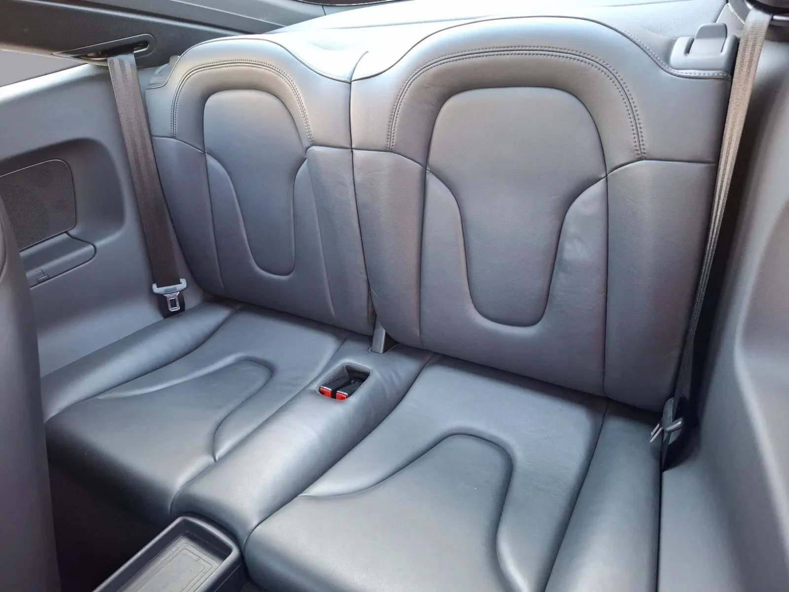 Vue rapprochée des sièges arrière en cuir gris foncé de l'Audi TT 3.2 V6 Quattro 2007, avec ceintures visibles.