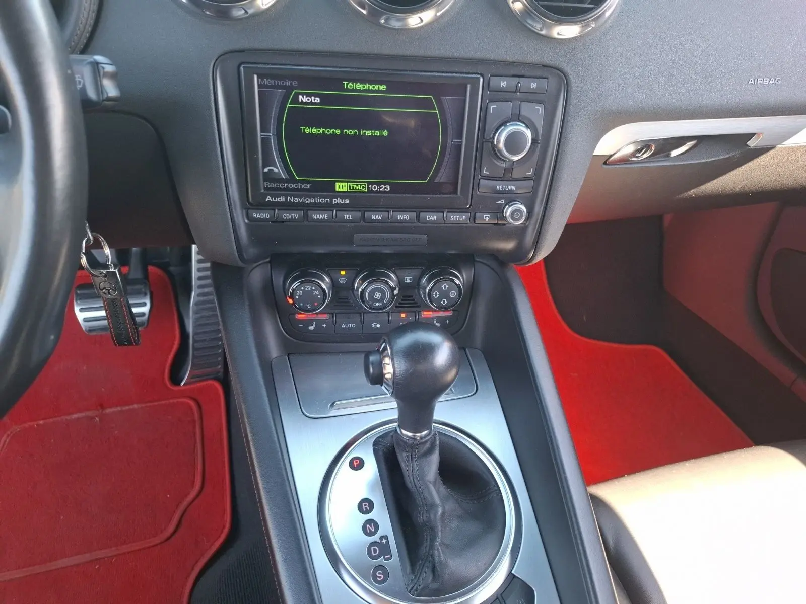 Vue rapprochée de la console centrale de l'Audi TT 3.2 V6 Quattro 2007 avec levier de boîte auto et tapis rouges.