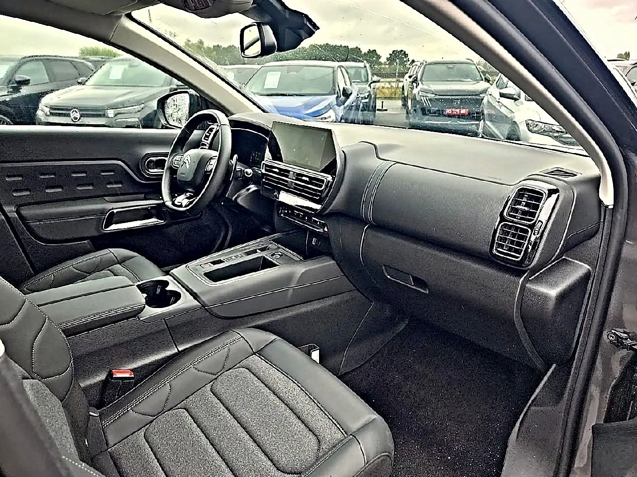 Vue intérieure côté conducteur du Citroën C5 Aircross gris 2025, avec tableau de bord moderne et écran tactile central.