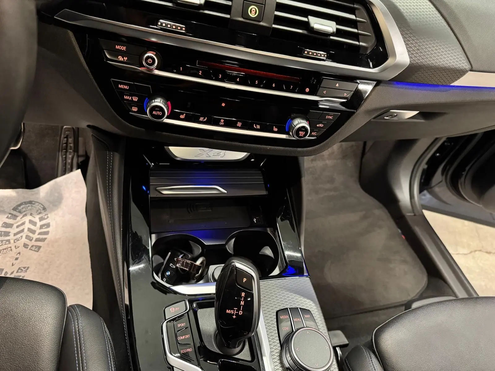Vue intérieure centrée sur la console centrale noire brillante du BMW X4 Carbonschwarz 2020 avec levier de vitesse automatique.