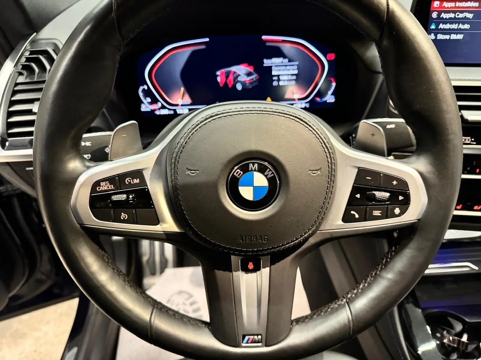 Vue rapprochée du volant cuir noir BMW X4 XDrive 20d 2020 avec commandes intégrées et tableau de bord numérique.
