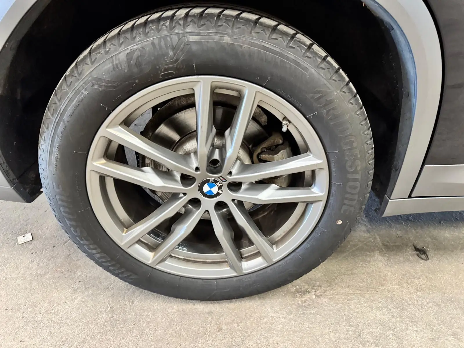 Gros plan sur la roue avant droite d'une BMW X4 XDrive 20d 2020 Carbonschwarz avec jante alliage 19 pouces.