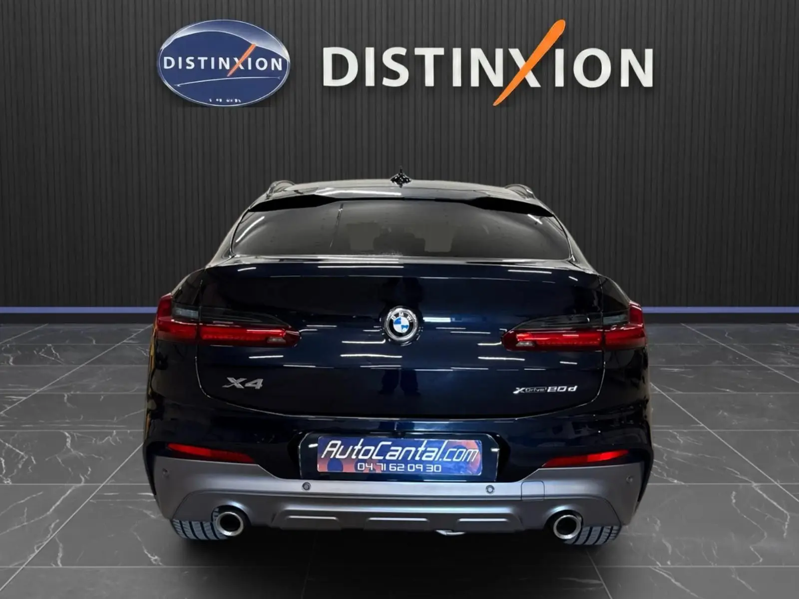 Vue arrière d'un BMW X4 XDrive 20d 2020 en Carbonschwarz, avec feux LED et double sortie d'échappement visibles.