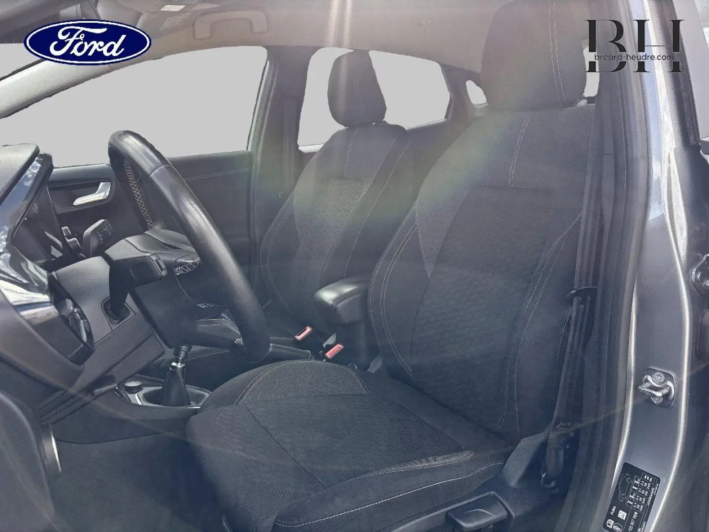 Intérieur de la Ford Puma 2023 gris Solar, vue côté conducteur avec sièges tissu et volant multifonction.