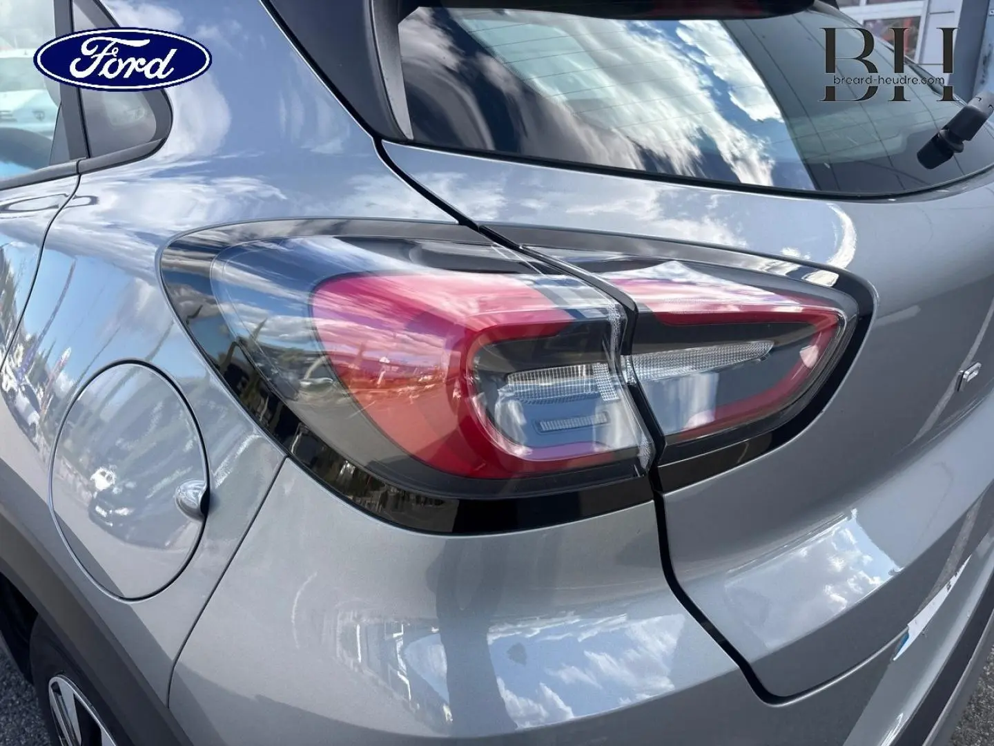 Gros plan sur le feu arrière droit d’un Ford Puma gris Solar métallisé, avec la trappe à carburant visible.
