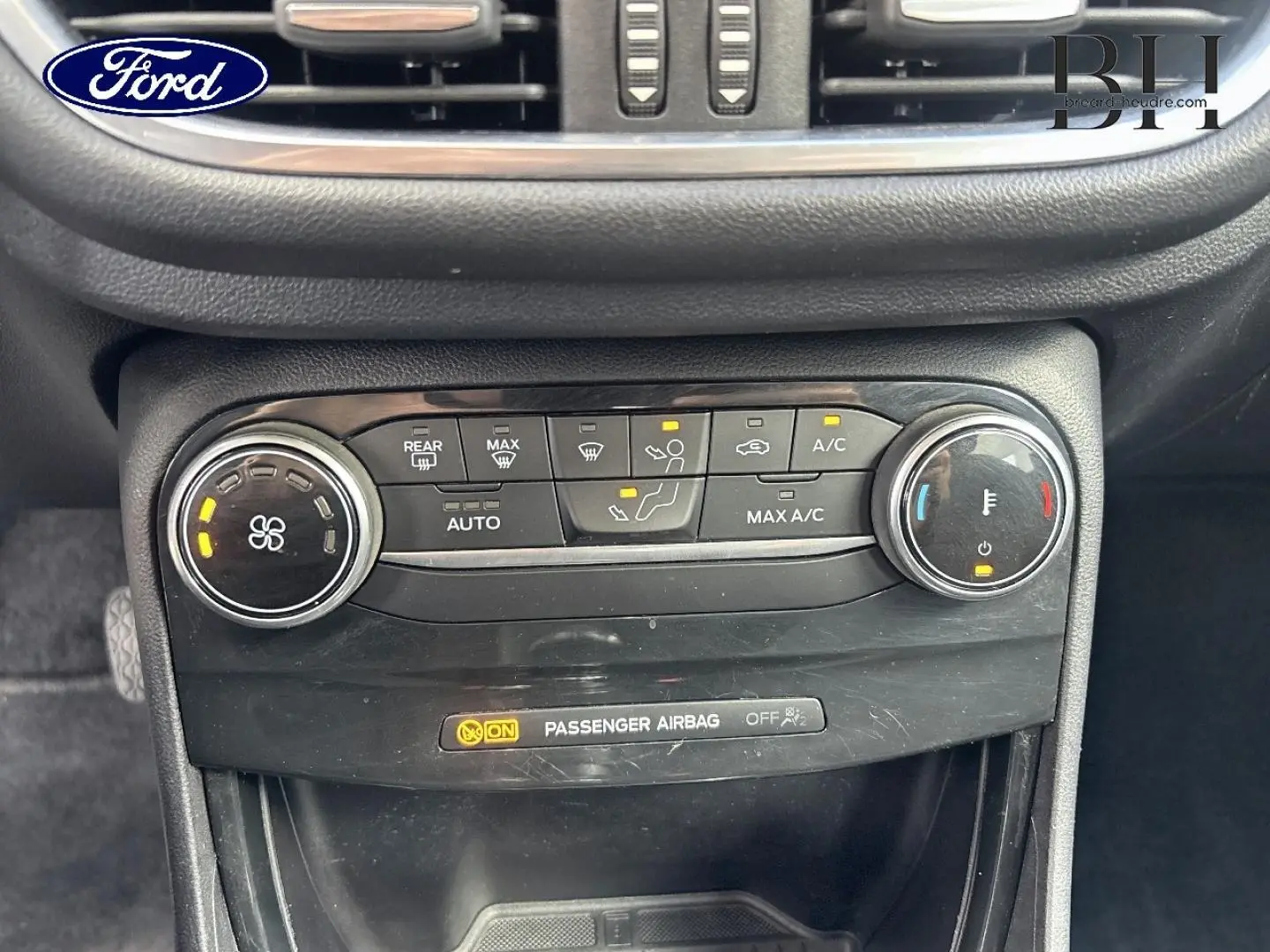 Gros plan sur la console centrale du Ford Puma 2023, montrant les commandes de climatisation et l'indicateur d'airbag passager.