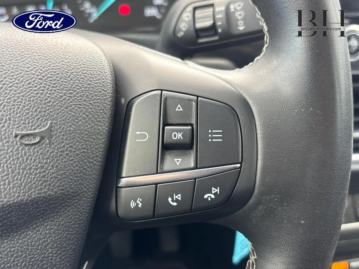 Gros plan sur les commandes multifonctions noires à droite du volant de la Ford Puma 2023, intérieur gris.