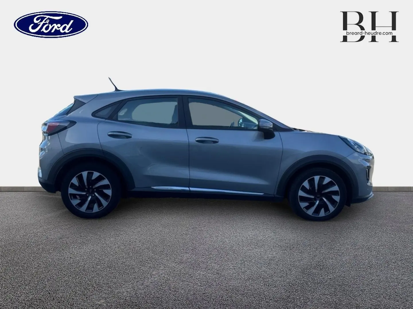 Ford Puma gris Solar métallisé vu de profil côté gauche, avec jantes alliage bicolores et poignées de porte ton caisse.