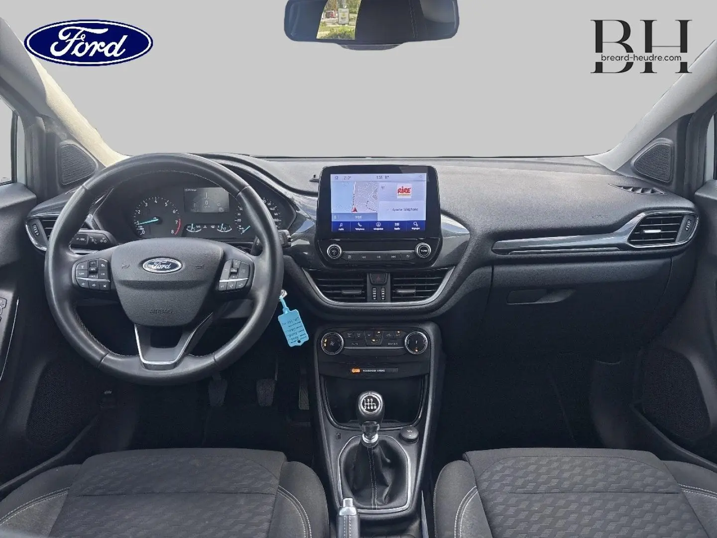 Vue intérieure avant du Ford Puma gris Solar Métallisée 2023 avec volant multifonction et écran tactile central.