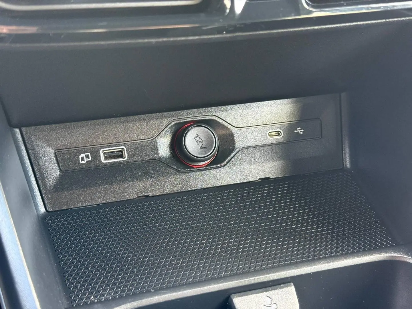 Gros plan sur la prise 12V et ports USB dans la console centrale noire du MG3 1.5 Hybrid+ 2025.