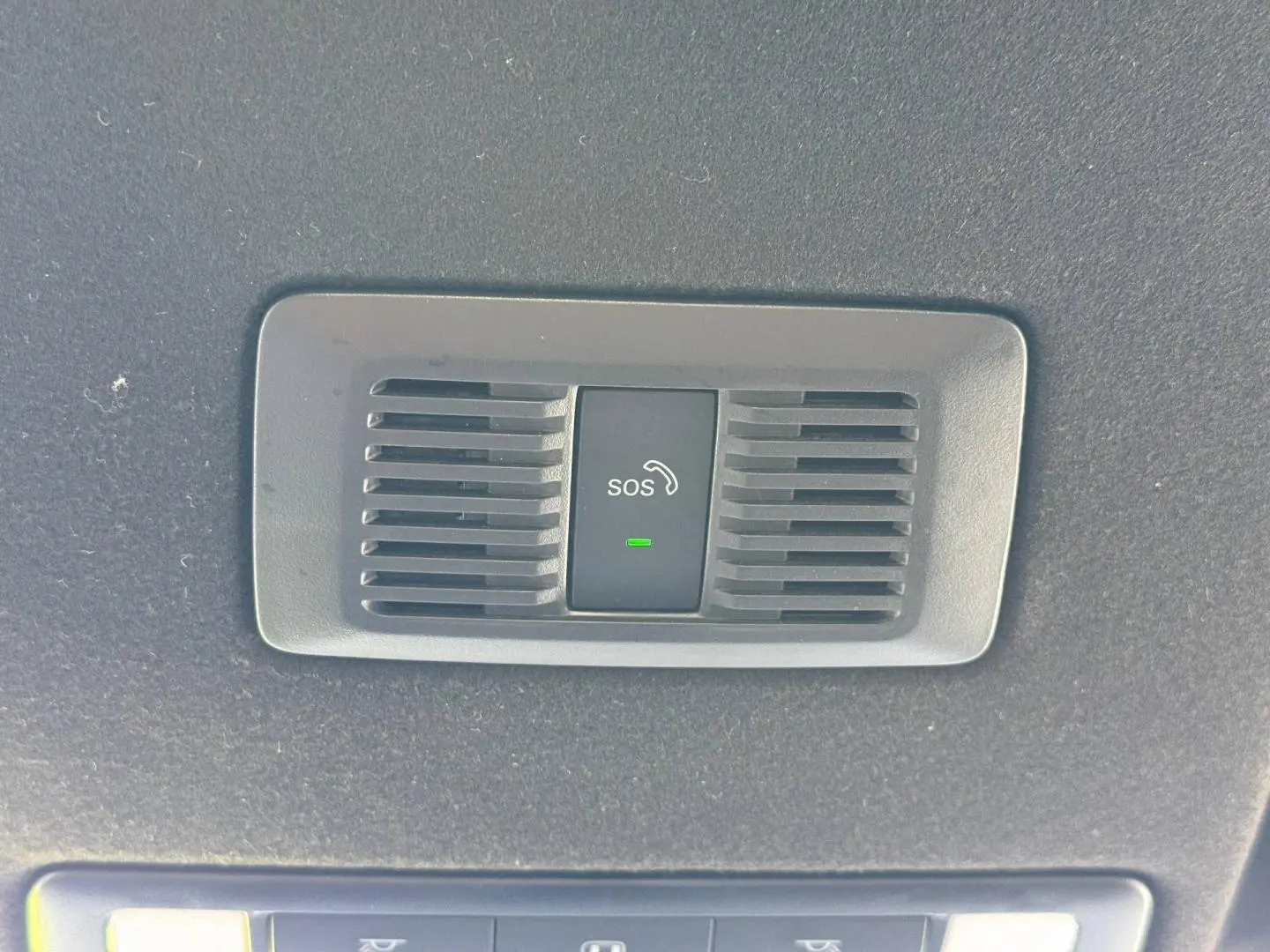 Bouton SOS noir avec icône téléphone et témoin vert, intégré dans le plafond intérieur d'une MG3 blanche.