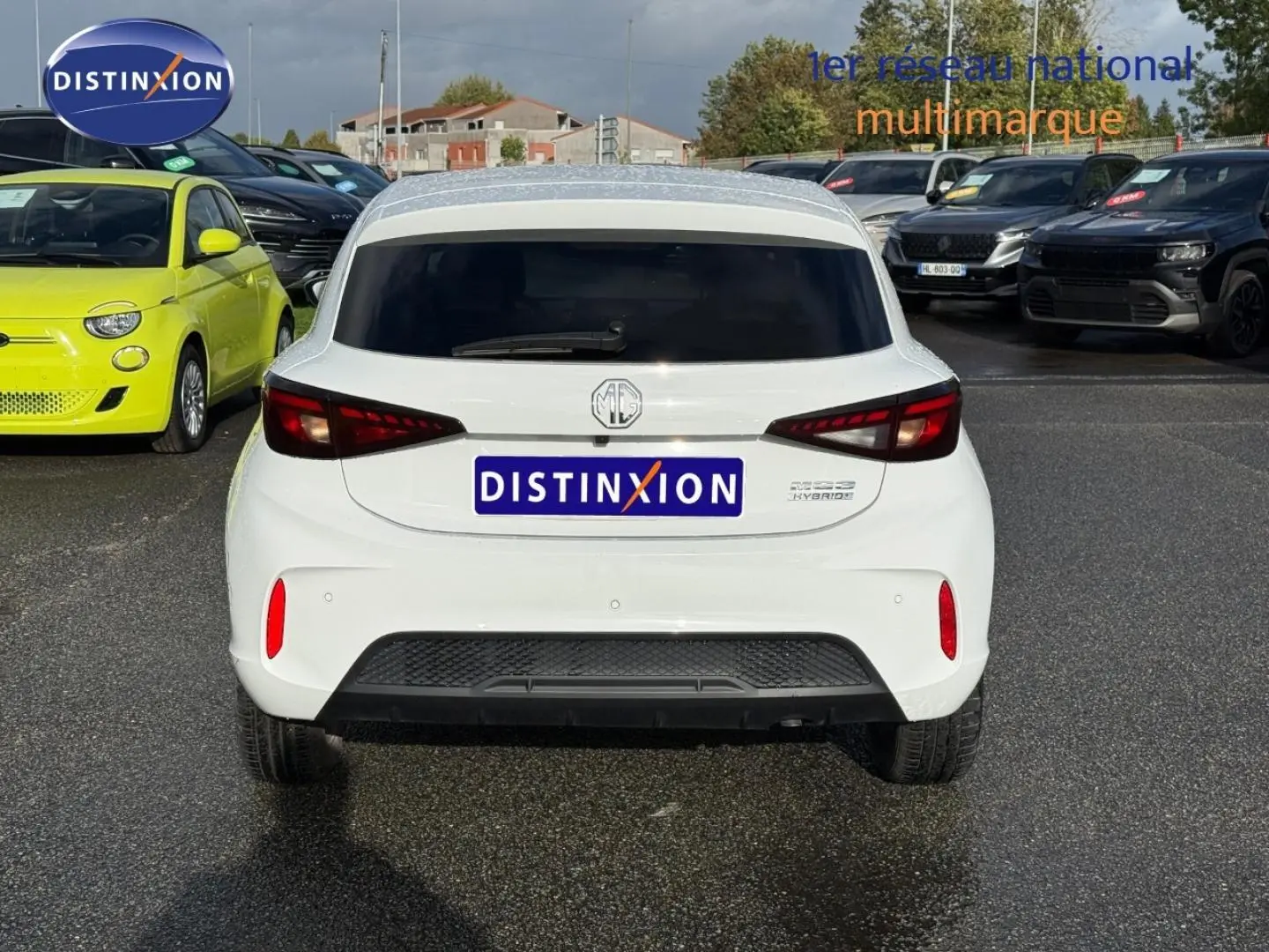 Vue arrière d'une MG3 blanche 2025 avec feux LED et vitres arrière surteintées sur parking extérieur.