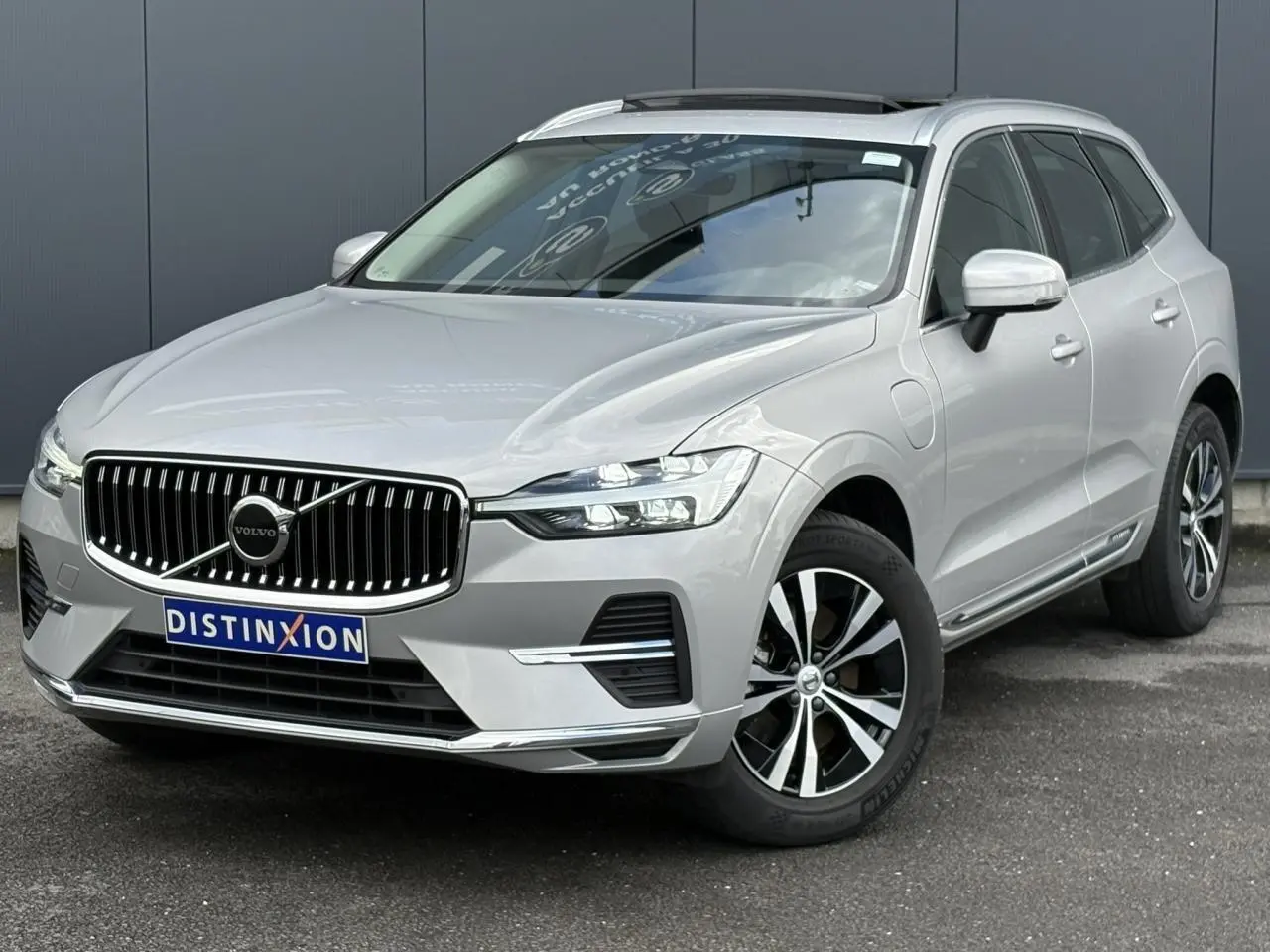 Vue 3/4 avant droit du Volvo XC60 gris silver avec calandre chromée et jantes alliage 18 pouces.