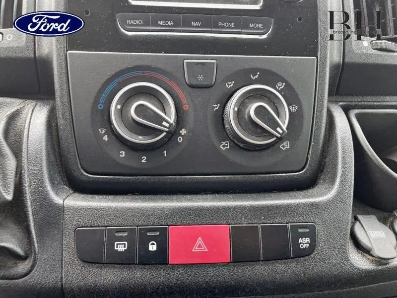 Gros plan sur la console centrale noire du Citroën Jumper FGN 2018 avec commandes clim manuelle et boutons de sécurité.