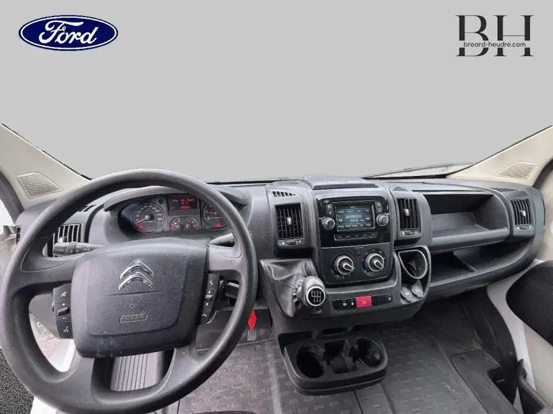 Vue intérieure du tableau de bord du Citroën Jumper blanc, avec volant multifonction et console centrale équipée d'un écran tactile.