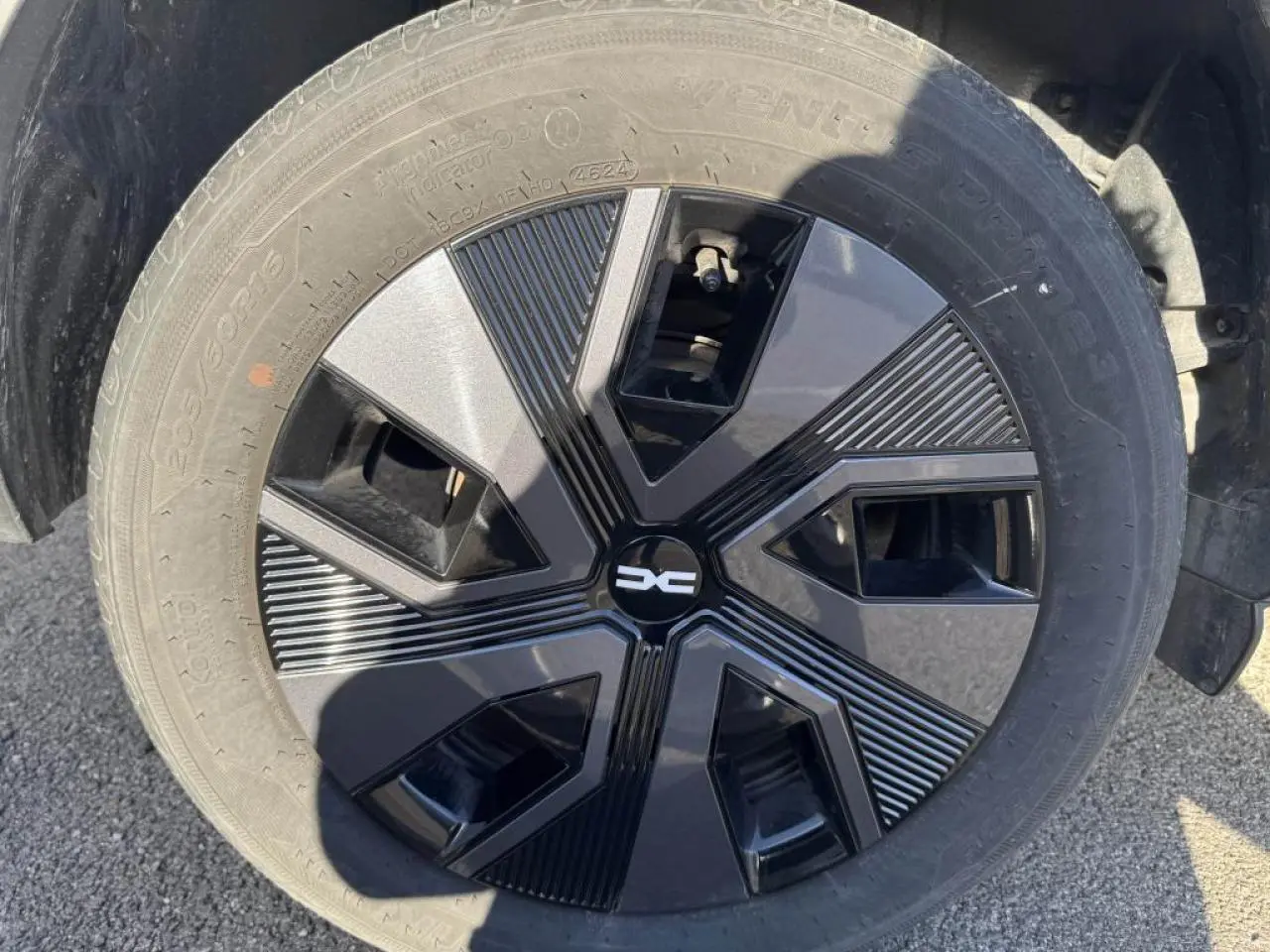 Gros plan sur la roue avec enjoliveur noir et gris du Dacia Jogger Gris Schiste 2025, détail du pneu visible.